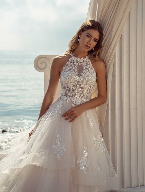 Romantic wedding dress with layered skirt and beaded bodice with halter neckline