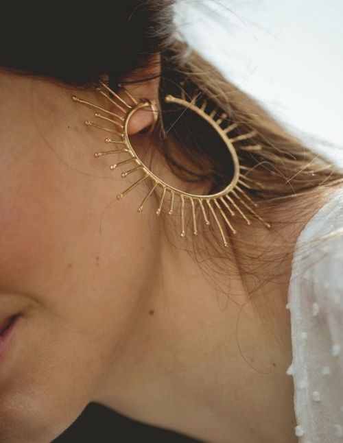 Circular golden earrings with small rays