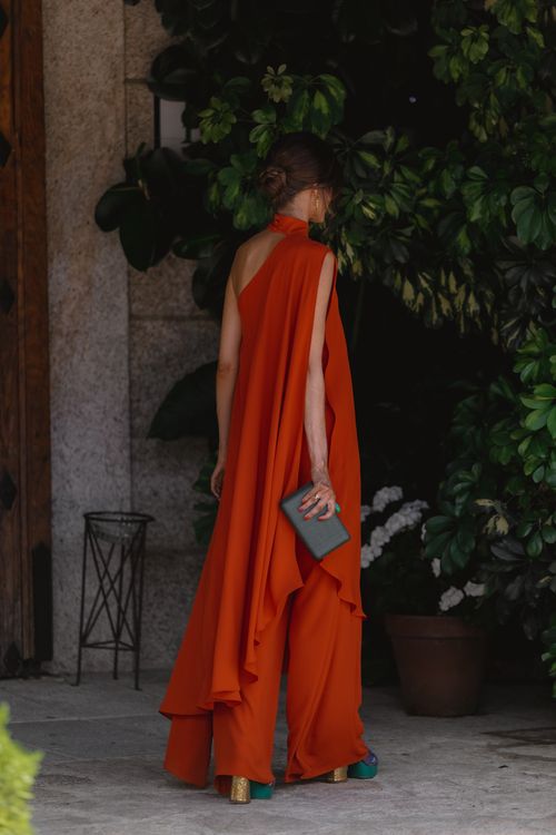 Long orange jumpsuit with long asymmetrical overlay